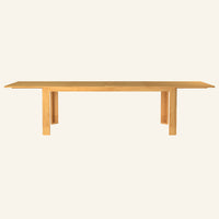 Forma dining table extended, front view of the solid teak tabletop and base