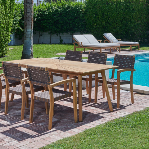 A poolside dining arrangement showcasing a teak dining table surrounded by woven teak chairs, creating a relaxing and stylish outdoor setting.