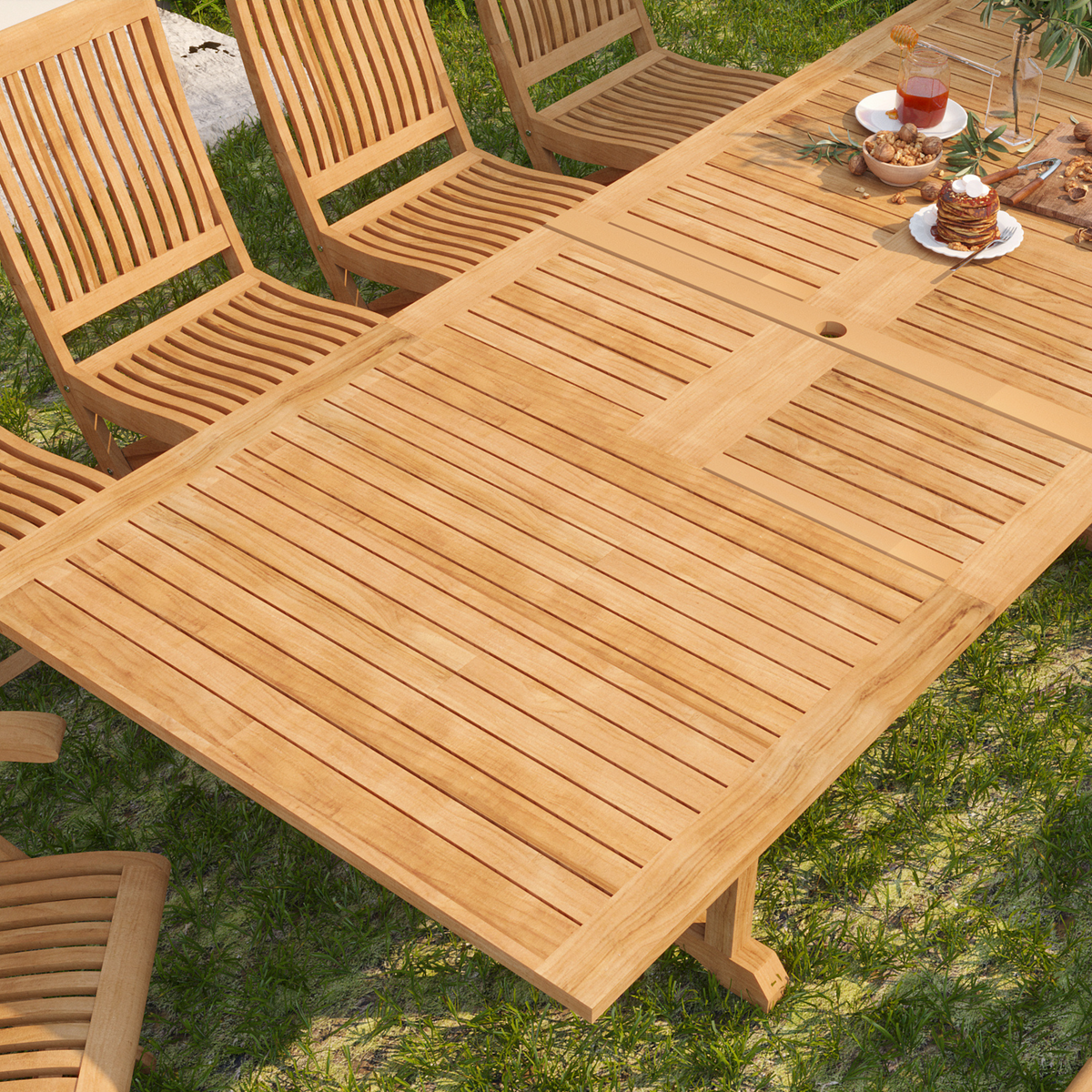 A close-up of the teak dining table's slatted surface, beautifully set for an outdoor brunch, highlighting the natural wood grain and craftsmanship in a lush garden setting.
