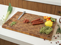 Wooden Teak cutting board with various ingredients on a kitchen counter